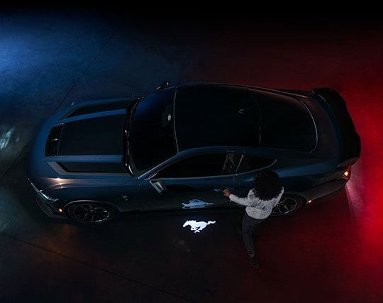 2024 Ford Mustang® Dark Horse™ model with a driver approaching the vehicle | Austin Ford in Austin MN