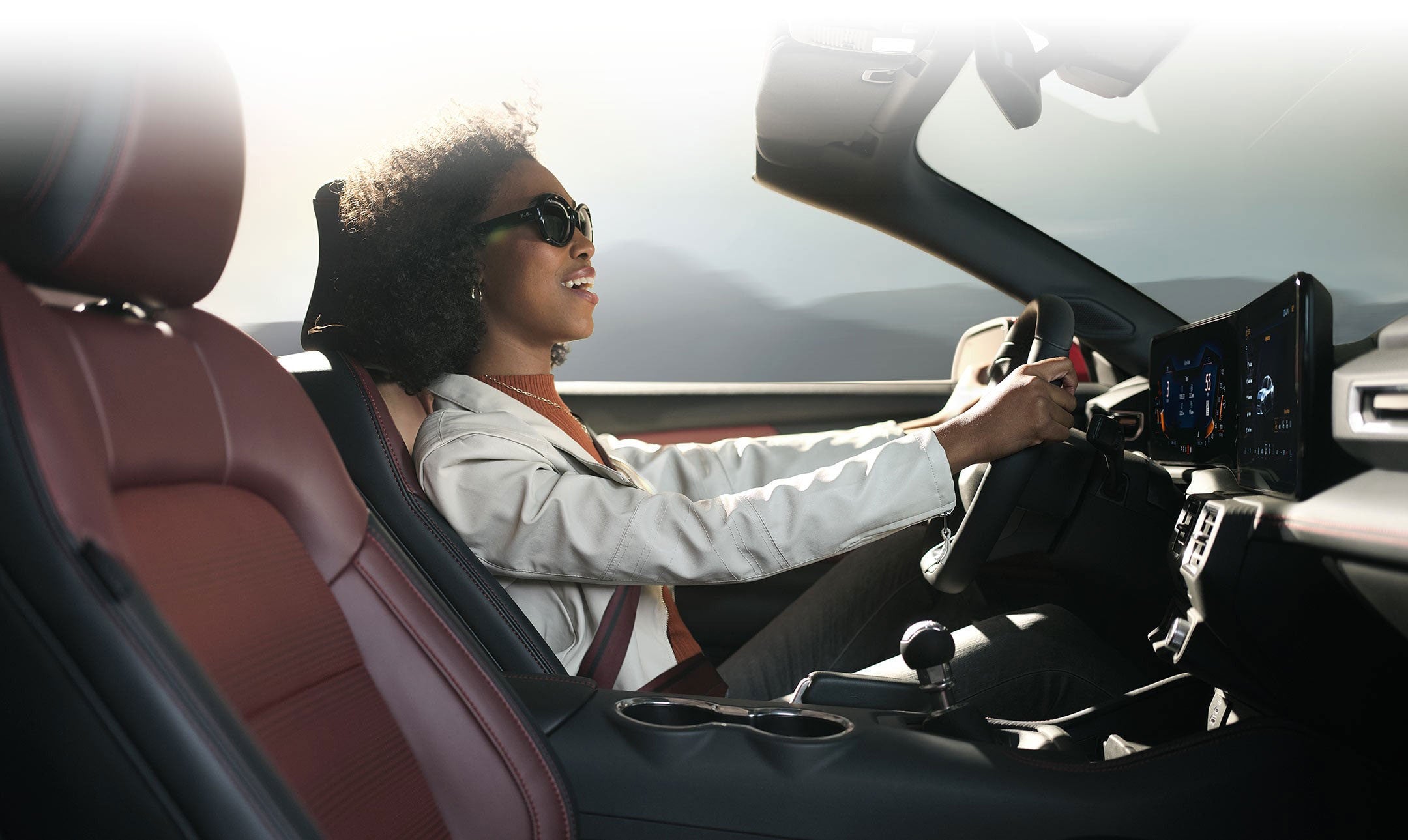Person sitting in the driver’s seat of a 2024 Ford Mustang® convertible | Austin Ford in Austin MN